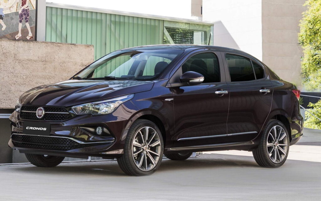 Os 5 modelos de carros usados que menos perderam valor em 2025 10 Carro sedan Fiat Cronos preto parado em piso claro ao lado de prédio com janelas verdes