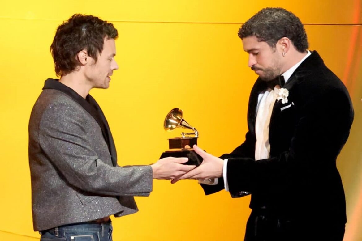 Harry Styles entregando troféu Grammy para Bad Bunny em palco iluminado