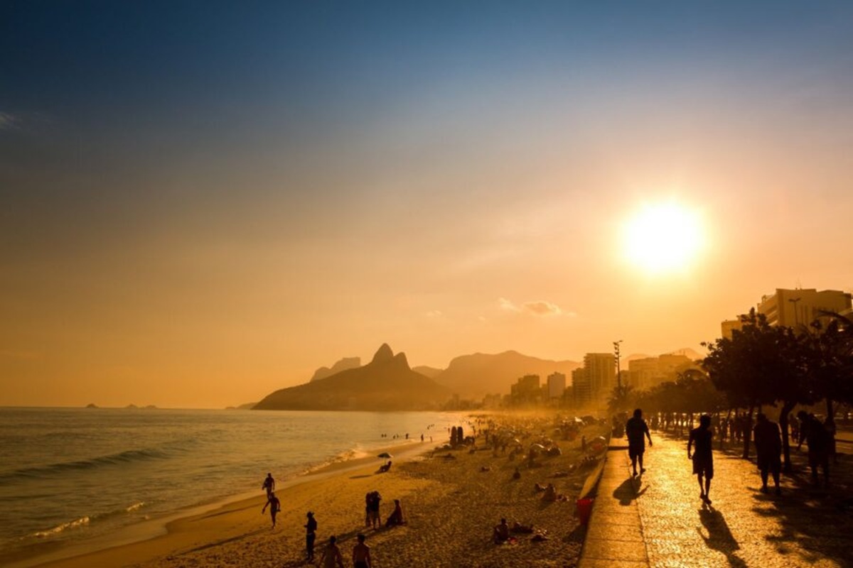 Melhores praias 2026: Tripadvisor revela as favoritas dos viajantes e surpreende com escolha brasileira 7 Pessoas caminhando e aproveitando o pôr do sol na Praia de Ipanema com céu alaranjado