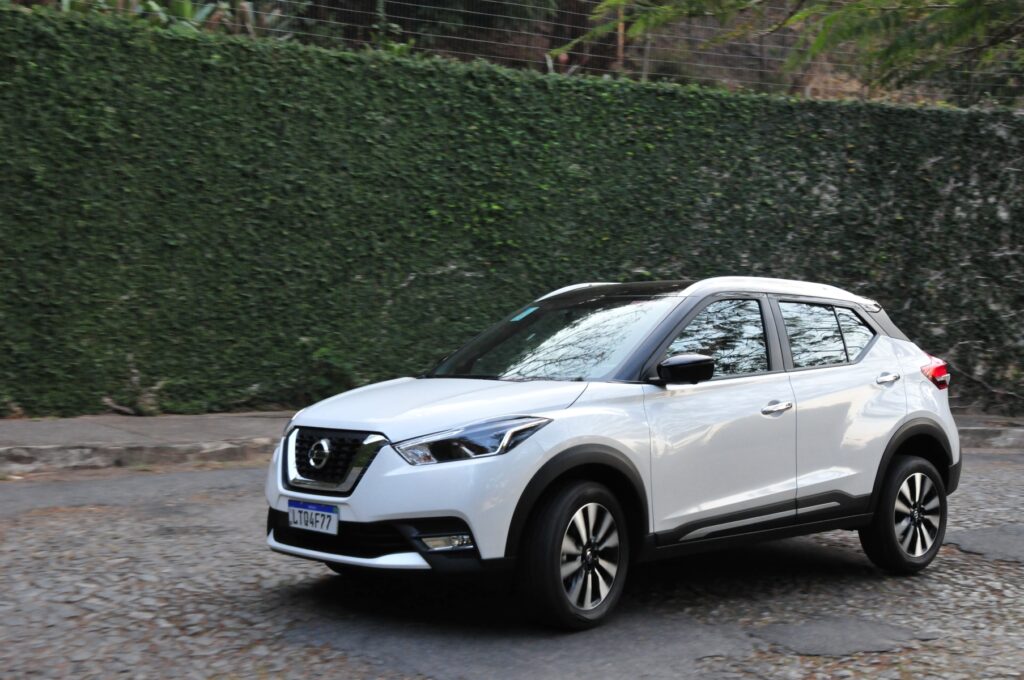 Os 5 modelos de carros usados que menos perderam valor em 2025 9 Veículo SUV branco circulando por rua de paralelepípedos ao lado de muro verde