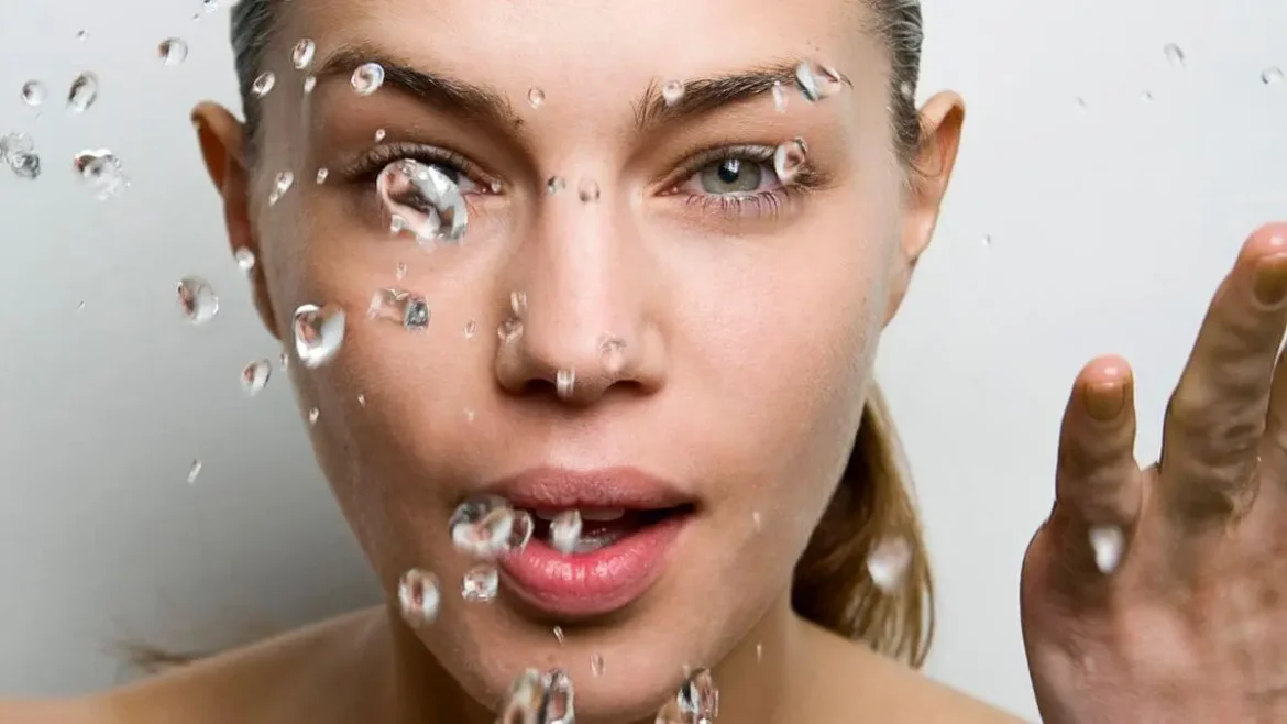 Mulher borrifa água no rosto mostrando efeito de limpeza com água com gás japonesa