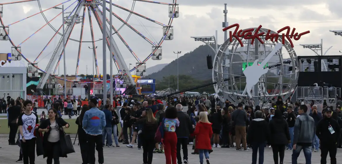 Vista da Cidade do Rock com roda-gigante Itaú e letreiro Rock in Rio ao fundo cercado de público