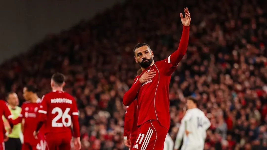 Champions League 2026: Veja os jogos decisivos das oitavas 6 Jogador do Liverpool de uniforme vermelho levanta o braço para a torcida em estádio cheio durante partida decisiva da Champions League.