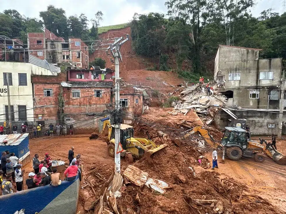 Bolsa Família e BPC antecipados em MG; governo também encaminha cestas de alimentos 6 Escavadeiras removem lama diante de casas destruídas após deslizamento, moradores observam operação