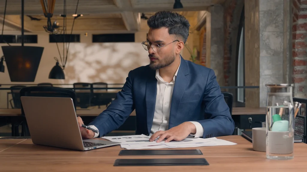 Exame Nacional dos Cartórios (ENAC) 2026: edital publicado! Fique por dentro das inscrições 6 Profissional analisando documentos em frente ao computador, representando o período de inscrições do 3º ENAC em 2026.