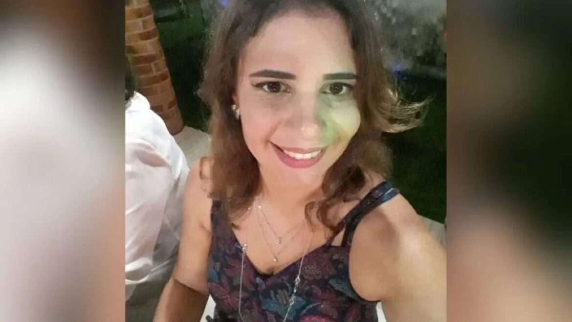 Professora Juliana Santiago sorrindo, com cabelos castanhos ondulados, usando colares delicados e uma blusa escura com estampas florais.