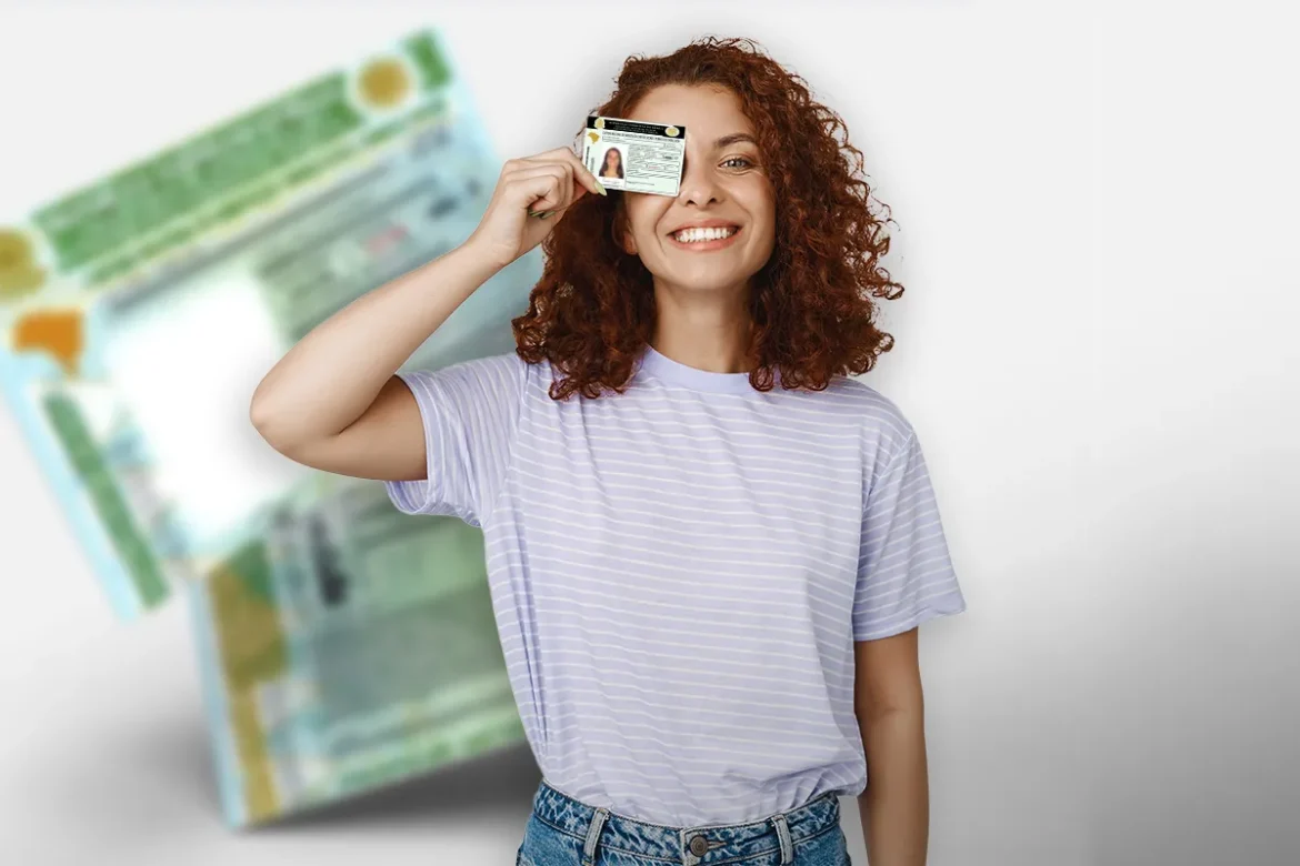 Mulher sorridente segura carteira de motorista próxima ao rosto, fundo desfocado.