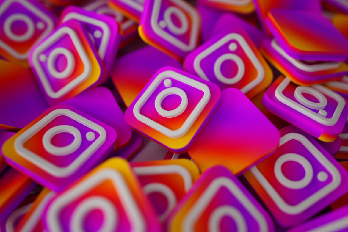 Múltiplos ícones tridimensionais do Instagram em rosa, roxo e laranja empilhados uns sobre os outros.