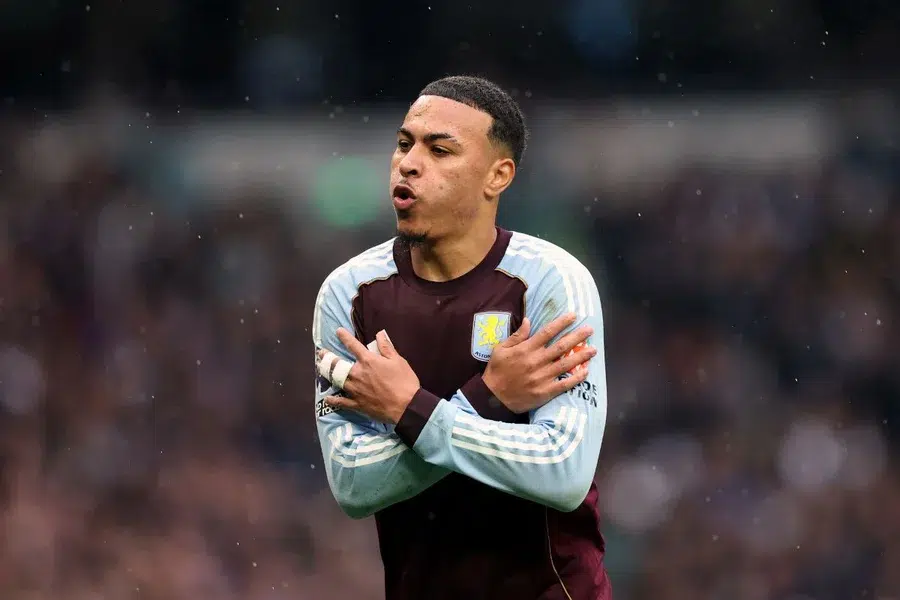 Jogos de hoje: Descubra onde assistir ao vivo antes do apito inicial 6 Jogador do Aston Villa celebrando em campo durante uma partida, com uma expressão de emoção e os braços cruzados.