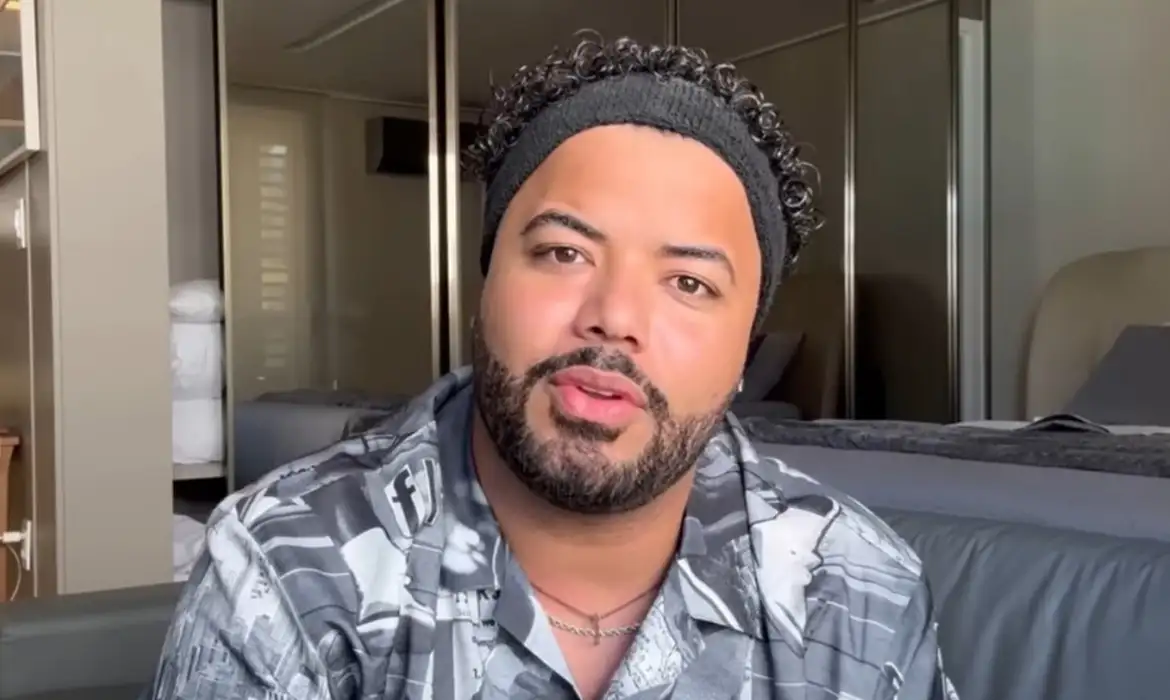 Influenciador Hytalo Santos é condenado por exploração sexual infantil; conheça os fatos 6 Close do influenciador Hytalo Santos falando para a câmera em um ambiente interno, vestindo uma camisa estampada em tons de cinza e preto e usando uma faixa preta no cabelo.