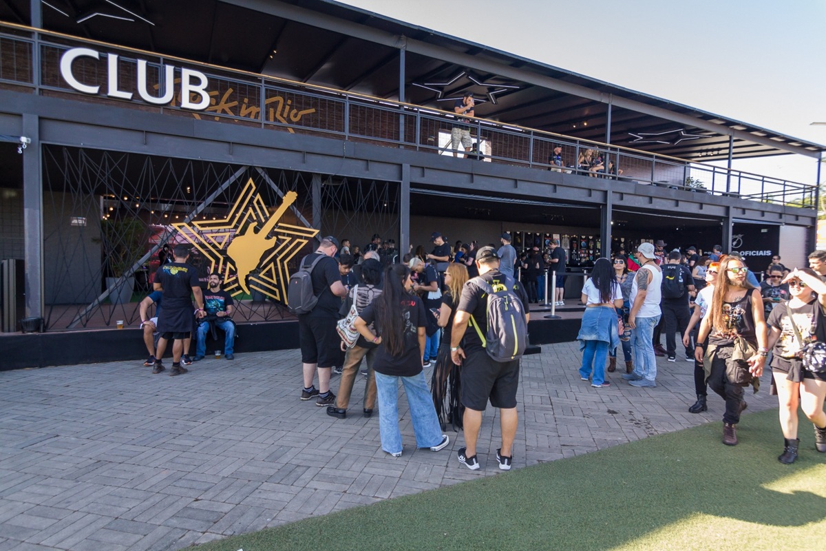 Rock in Rio 2026: Avenged Sevenfold é headliner e Bring Me The Horizon se apresenta pela primeira vez 6 Público circulando em frente ao Club Rock in Rio com logo da guitarra dourada e estrutura do festival ao fundo