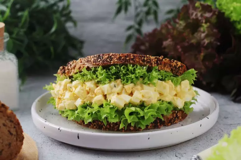 Sanduíche de Ovo Cremoso: 3 receitas fáceis e sabor imbatível para seu lanche da tarde 6 Sanduíche de ovo cremoso e alface servido em prato branco sobre bancada