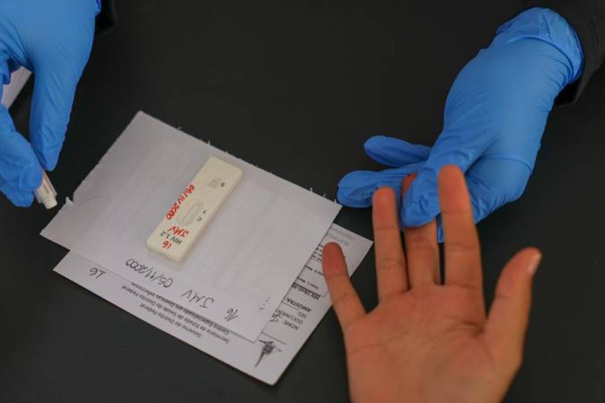 Brasil elimina a transmissão do HIV de mãe para bebê 6 Mulher grávida com as mãos na barriga em ambiente iluminado, representando a prevenção da transmissão do HIV de mãe para bebê no Brasil.