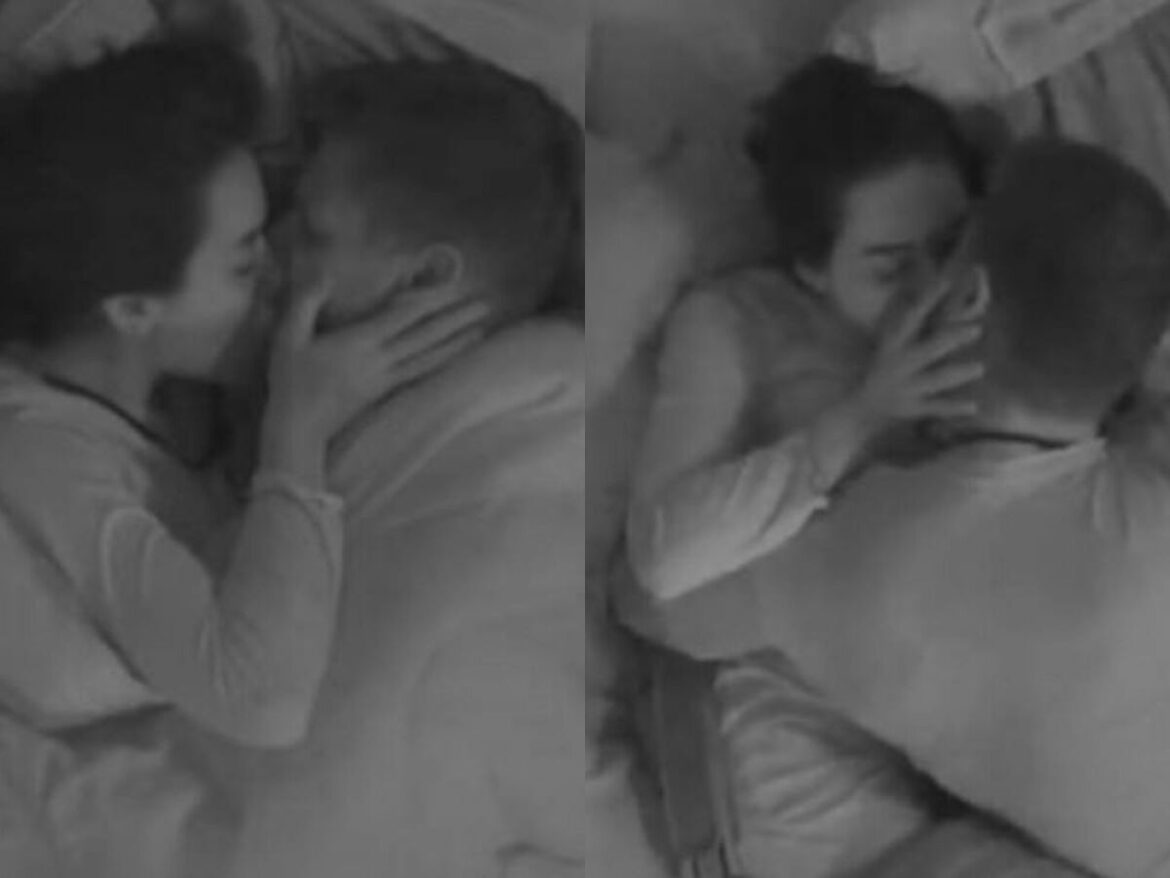 Jonas e Jordana deitados, se beijando sob o edredom, com as mãos nos rostos, no BBB 26