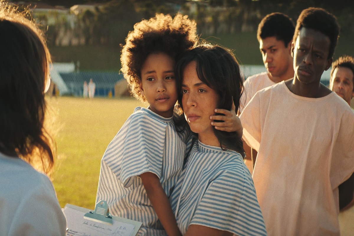 Emergência Radioativa: 20 segredos sobre o Césio 137 que a série da Netflix não conta 6 Mãe segurando filha pequena em fila de triagem com pessoas ao fundo