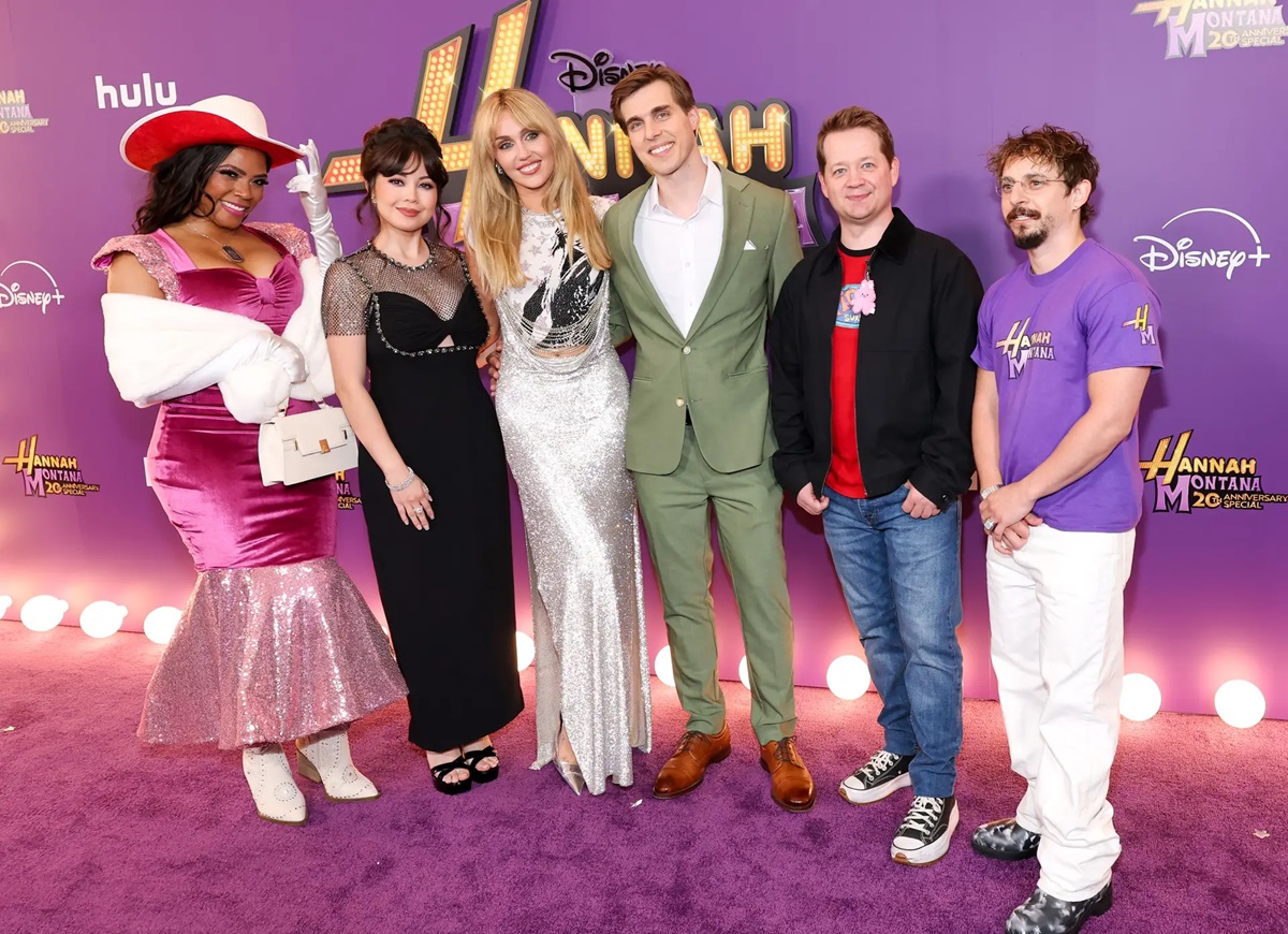 Especial de "Hannah Montana 20 anos" chega ao Disney+ nesta terça-feira (24) 6 Seis pessoas posando sorridentes em tapete roxo decorado com o logo do especial da série