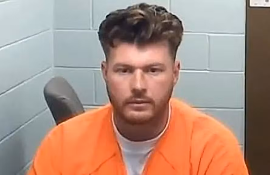 Homem é condenado à prisão por decapitar gaivota que tentou roubar batata frita da filha 6 Fotografia de busto de Franklin Ziegler, um homem jovem de pele clara, com cabelos castanhos curtos e volumosos no topo e barba rala. Ele veste um uniforme de detento na cor laranja sobre uma camiseta branca. O fundo é composto por uma parede de blocos de concreto em tom azul-claro. Ele encara a câmera com uma expressão séria e neutra.