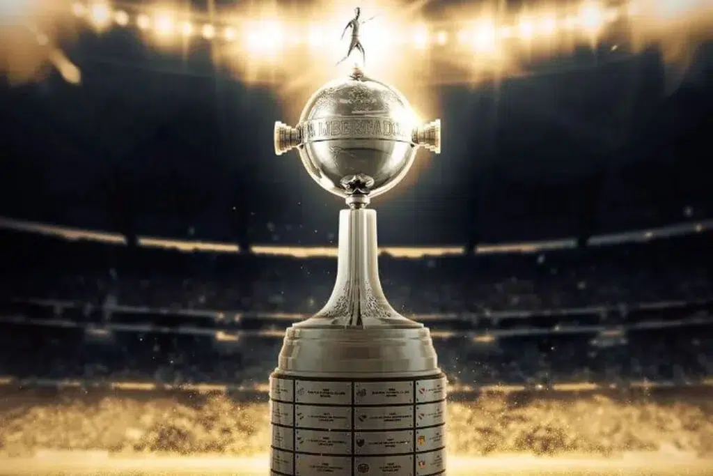 Libertadores 2026: Confira os grupos definidos após sorteio 6 Troféu da Libertadores exposto no gramado, cercado por luzes douradas no estádio