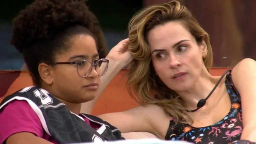 Tensão no BBB 26: atitude de Ana Paula com Milena mexe com a aliança 6 Milena e Ana Paula sentadas no sofá da casa do BBB 26 durante um momento dentro do reality.