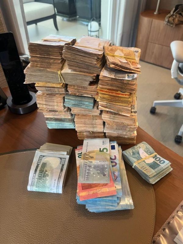Daniel Vorcaro, dono do Banco Master, é preso novamente pela PF nesta quarta-feira (04) 6 Pilhas de maços de dinheiro em notas de Real, Dólar e Euro sobre uma mesa de escritório, apreendidas durante a Operação Compliance Zero da Polícia Federal.
