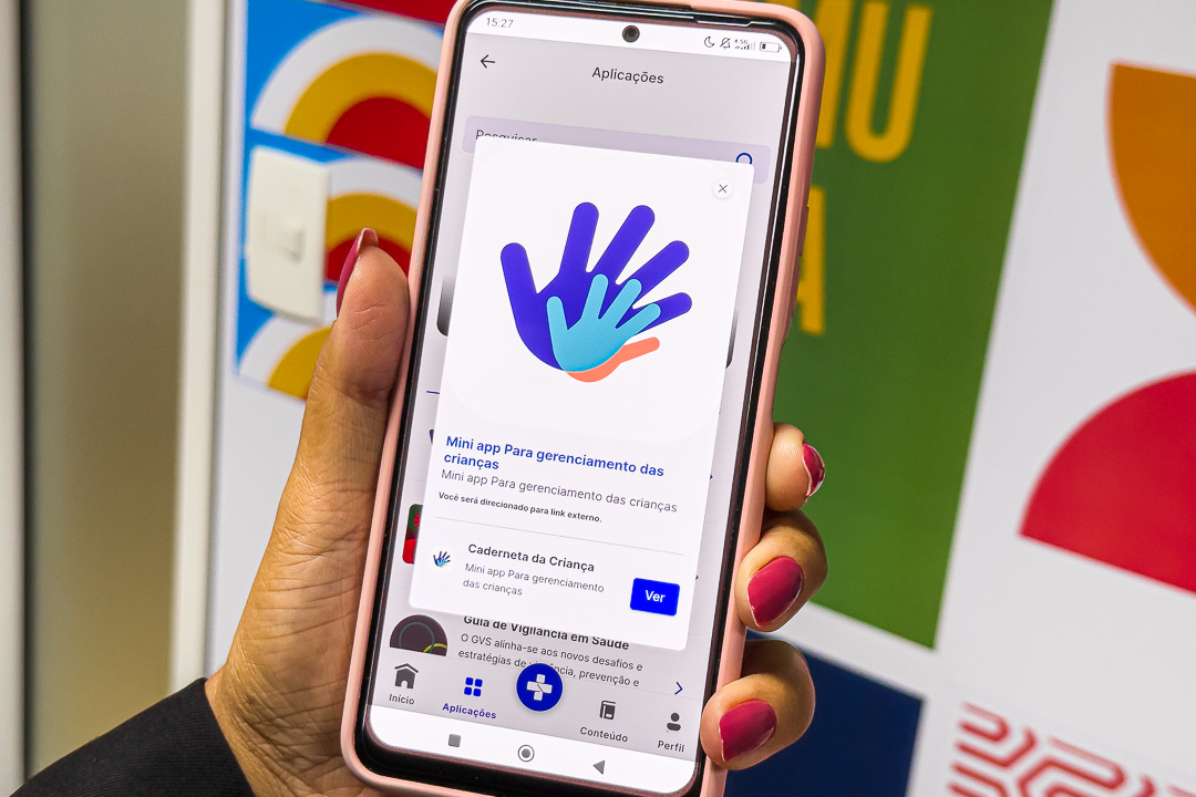 App Meu SUS Digital agora permite marcar, remarcar e cancelar consultas 6 Pessoa segurando celular com tela do aplicativo Meu SUS Digital exibindo recursos de saúde e serviços para usuários do SUS.