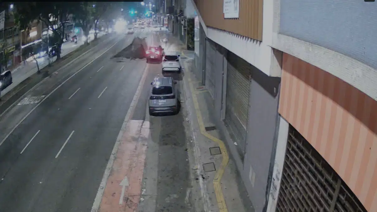 Explosão na Consolação: Enel revela que acúmulo de gases foi a causa — entenda o que aconteceu 6 Explosão na Rua da Consolação em São Paulo — imagem de câmera de segurança mostra o momento exato em que o asfalto se rompe com a força da explosão subterrânea, com um carro vermelho a poucos metros da cratera e poeira se espalhando pela via durante a noite