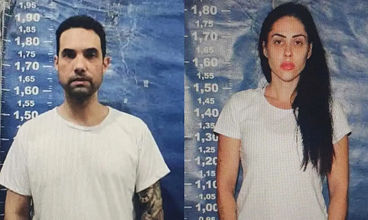 Mãe de Henry Borel, acusada de participação na morte do filho, deixa a cadeia 6 Duas pessoas em frente a painel de altura policial, ambos com camiseta branca e expressão séria