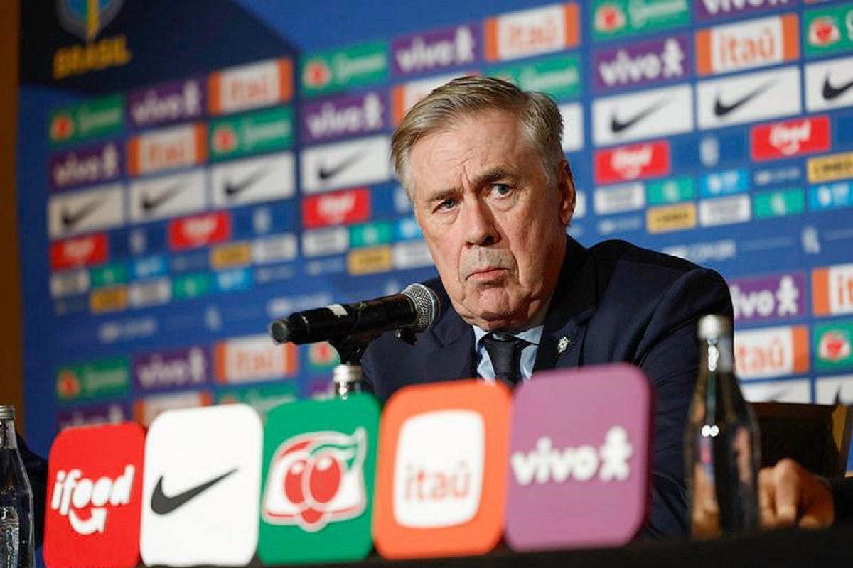 Neymar terá última chance? Ancelotti define convocação da Seleção Brasileira para amistosos decisivos 6 Técnico sentado em coletiva de imprensa com microfone e painéis de patrocinadores ao fundo