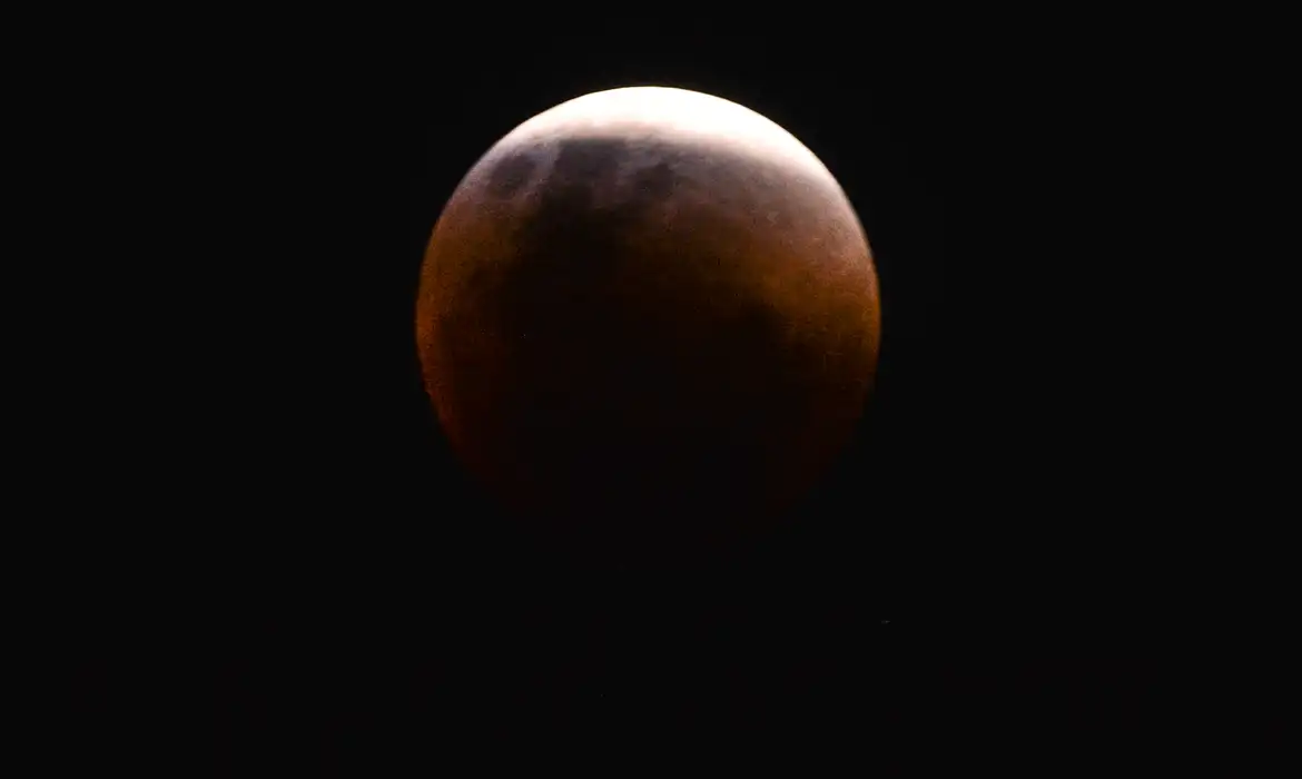 Saiba como será a Lua de Sangue amanhã, 03/03 6 Lua de Sangue em tom avermelhado e acobreado durante o eclipse lunar total de 2026, com parte da superfície ainda iluminada