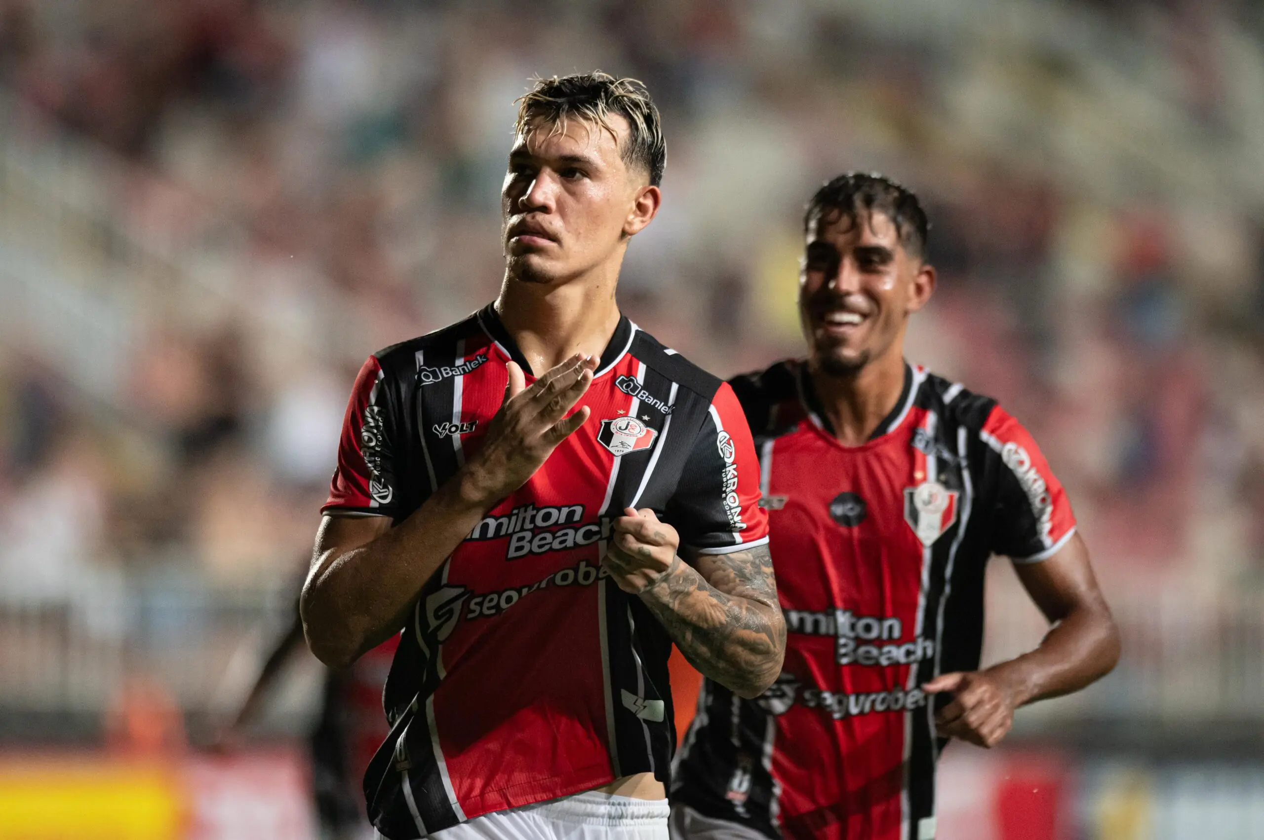 Clube brasileiro aposta em Filipe Luís após saída polêmica do Flamengo 6 Dois jogadores do clube brasileiro comemoram gol em campo, vestindo uniforme rubro-negro