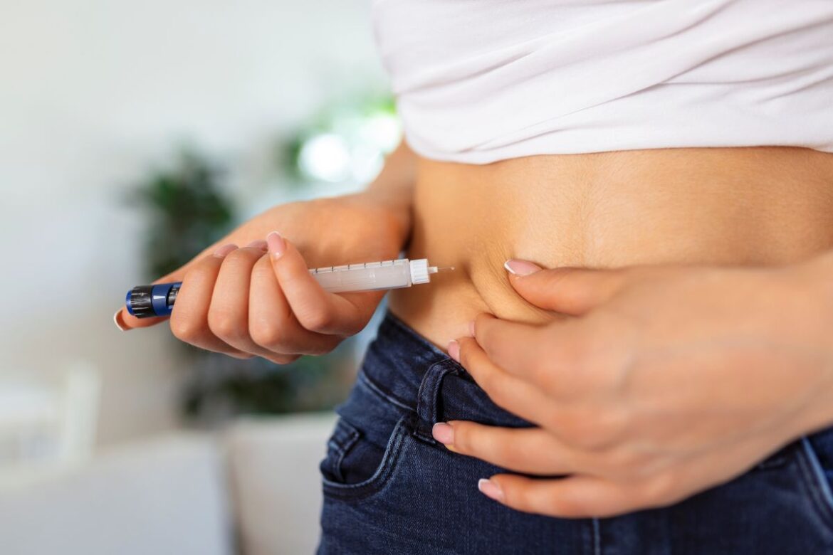 Pessoa aplicando injeção subcutânea de medicamento para controle de obesidade, ilustrando o uso de Wegovy nos centros de saúde.