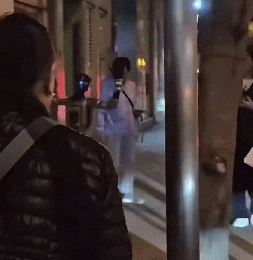 Robô humanoide é preso acusado de importunar idosa 6 Agente de polícia aborda robô humanoide na calçada durante a noite