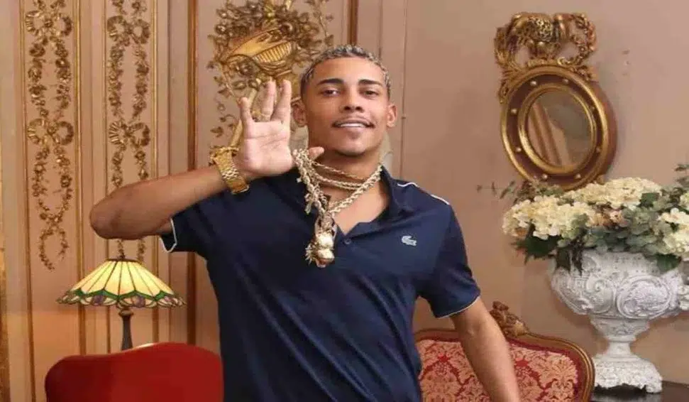 Após sofrer roubo milionário, MC Poze do Rodo promete vingança; assista ao vídeo do assalto 6 MC Poze do Rodo usa várias correntes douradas, faz gesto com a mão, veste camisa azul escura e está em sala decorada