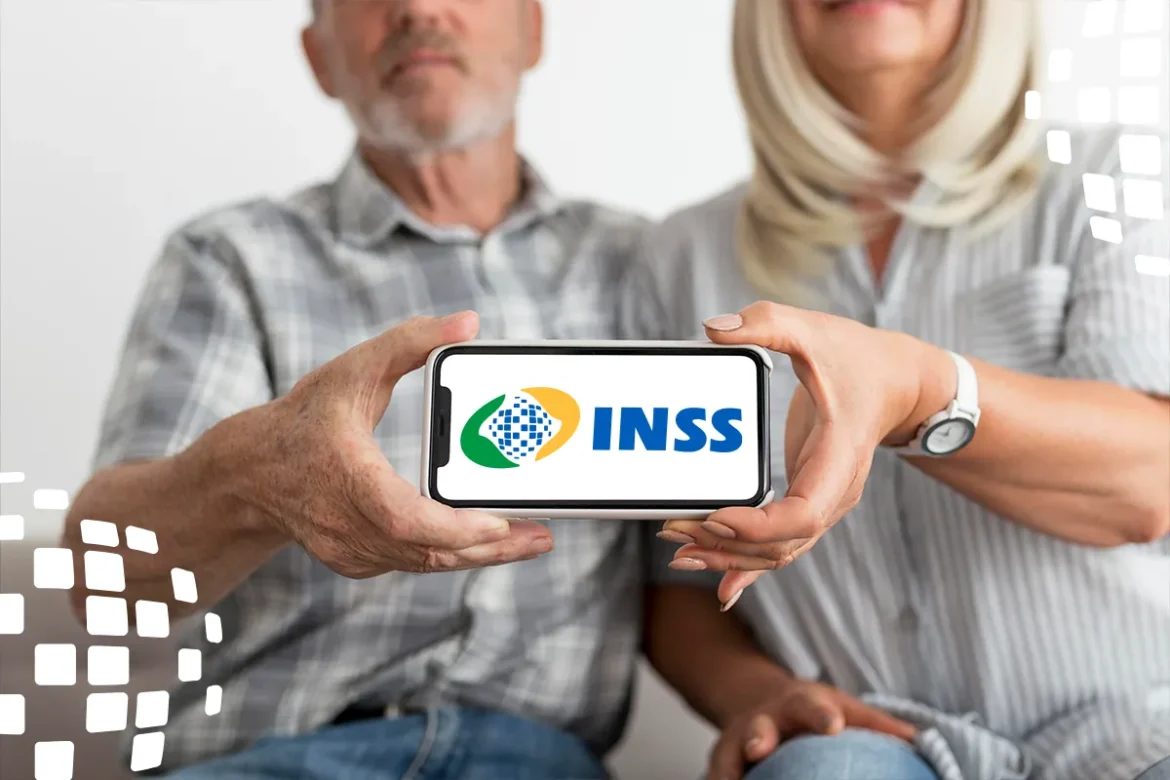 Casal idoso sentado segurando smartphone horizontal com logotipo azul do INSS na tela, fundo claro