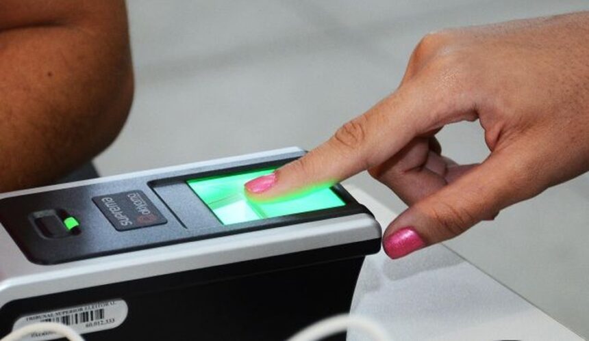 Beneficiários de programas sociais têm até 31 de dezembro para fazer cadastro biométrico 6 Dedo indicador feminino com esmalte rosa posicionado sobre leitor biométrico com luz verde em processo de coleta digital