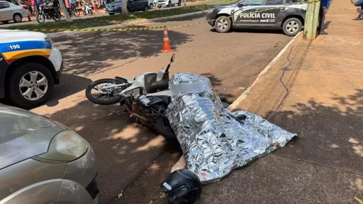 Corpo sob manta térmica ao lado de moto caída, viaturas da PM e Polícia Civil isolam local de execução em Frutal