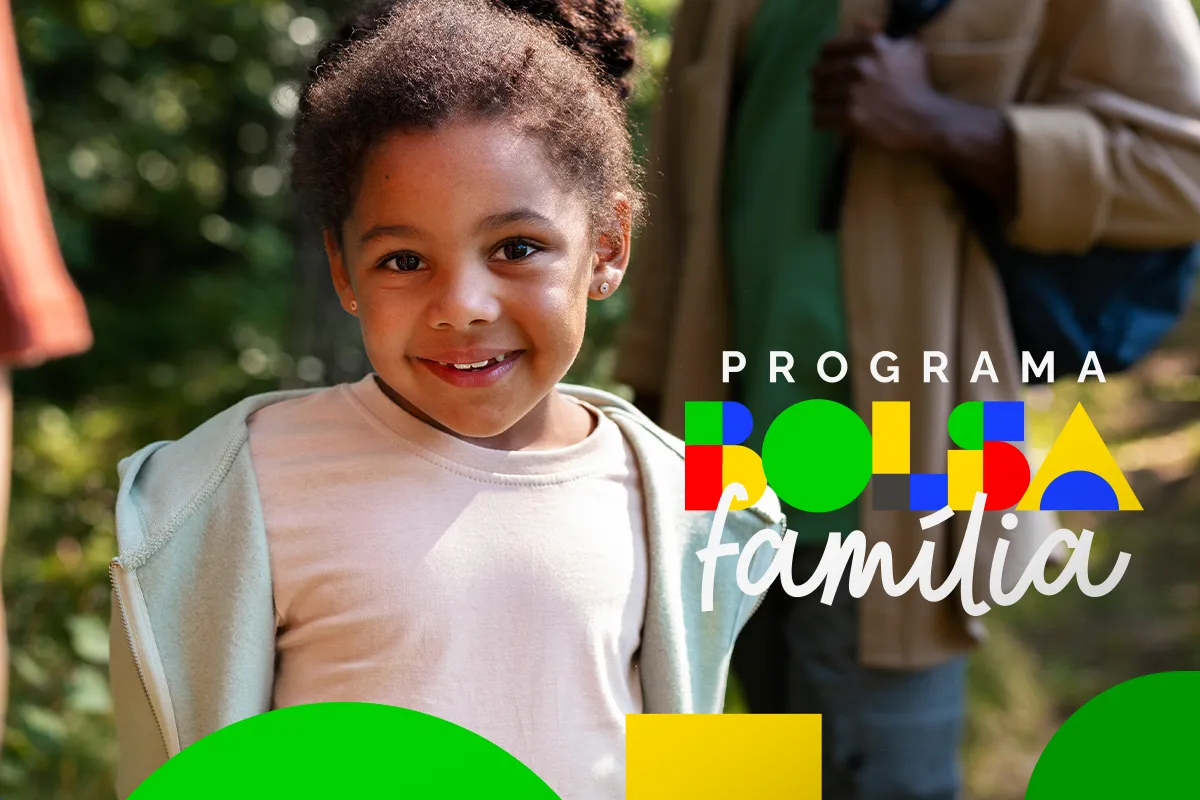 Confira o calendário do Bolsa Família para maio e os valores que serão pagos 6 Criança negra sorridente com cabelo cacheado e brinco usando blusa clara em ambiente verde com logotipo do Bolsa Família
