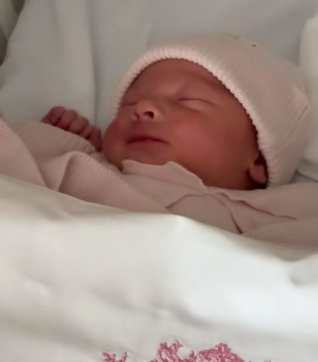 O que é bronquiolite, doença que atinge a filha de Maíra Cardi? 6 Close do rosto da bebê Eloah, filha de Maíra Cardi, dormindo tranquilamente. Ela usa uma touca de lã rosa claro e está coberta por uma manta branca com bordados delicados em rosa na borda.