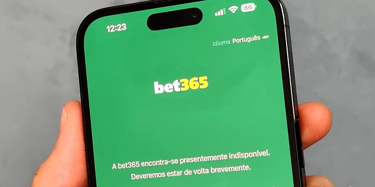 Por que a Bet365 saiu do ar no Brasil? Veja o que aconteceu 6 Tela de smartphone exibindo aplicativo Bet365 com mensagem de indisponibilidade temporária em fundo verde
