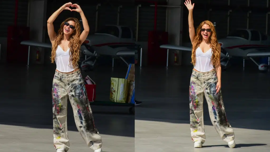 Shakira no Rio: saiba como será o esquema para segurança e transporte do show 6 Shakira com cabelos loiros ondulados, blusa branca e calça larga estampada, acena e faz coração com mãos em hangar