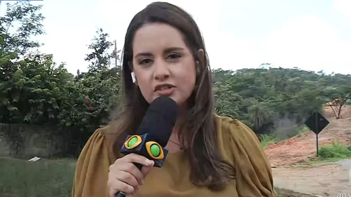 A jornalista Alice Ribeiro, da Band Minas, segurando um microfone com a logomarca da emissora durante uma reportagem externa em local com vegetação ao fundo.