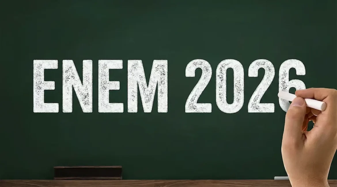 Texto na lousa com a inscrição ENEM 2026, com uma mão escrevendo, representando o prazo para solicitar isenção da taxa de inscrição até esta sexta-feira, 24 de abril.