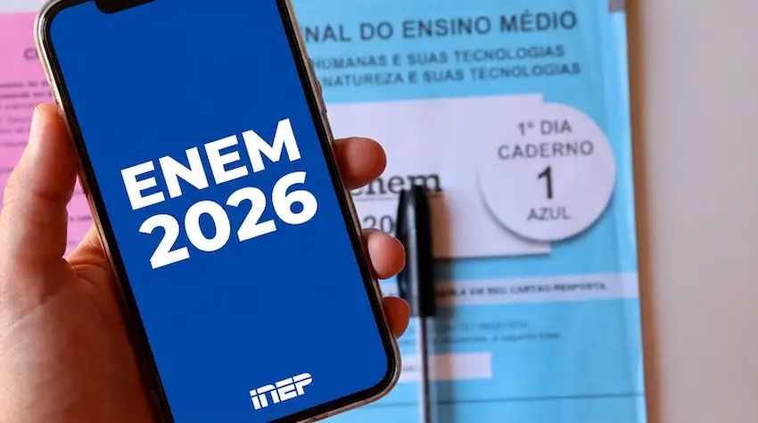 Enem 2026: termina nesta sexta (24) o prazo para solicitar isenção da taxa de inscrição 6 Imagem de um celular com a tela mostrando 'ENEM 2026', com um caderno do ENEM e uma caneta ao fundo, simbolizando o processo de inscrição e isenção para o ENEM 2026.