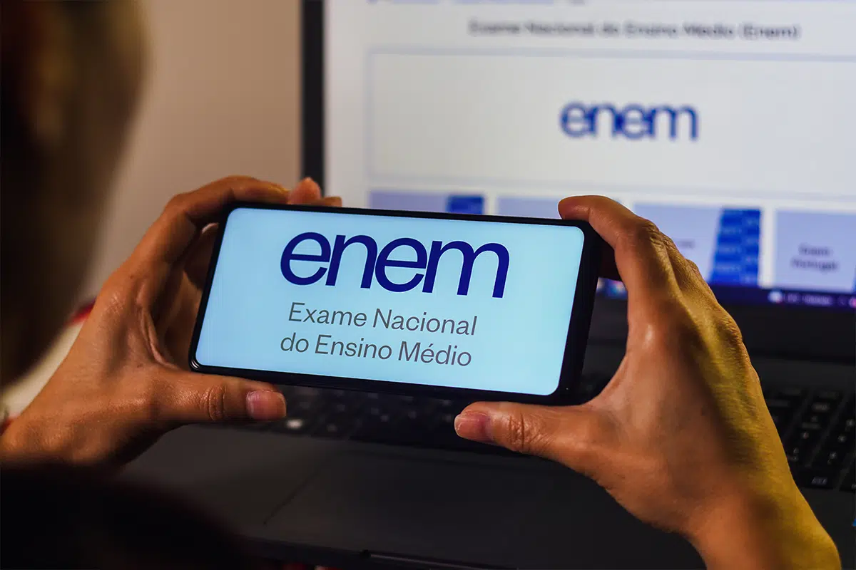 Ainda dá tempo! MEC prorroga o pedido de isenção da taxa do Enem 6 Pessoa segurando celular com página do Enem aberta para solicitar isenção da taxa
