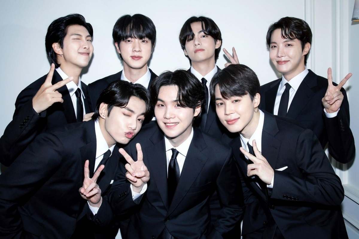 BTS no Brasil em 2026: Ingressos, Datas e Tudo Sobre os Shows no MorumBis 2 Sete membros do BTS em ternos pretos e camisas brancas posam sorridentes fazendo sinais de paz