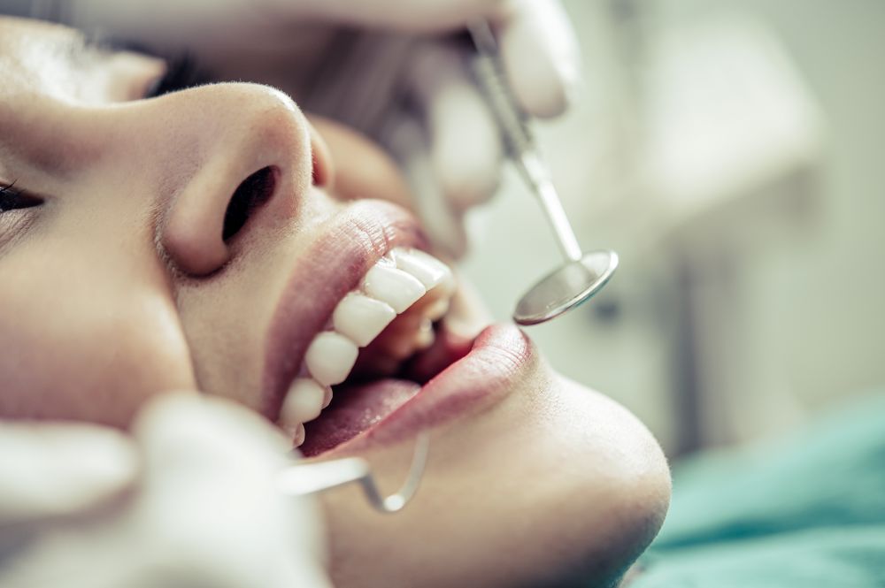 SUS oferece reconstrução dentária gratuita para vítimas de violência doméstica 6 Close do sorriso de uma paciente recebendo atendimento odontológico especializado, simbolizando a recuperação da saúde bucal pelo programa do SUS.