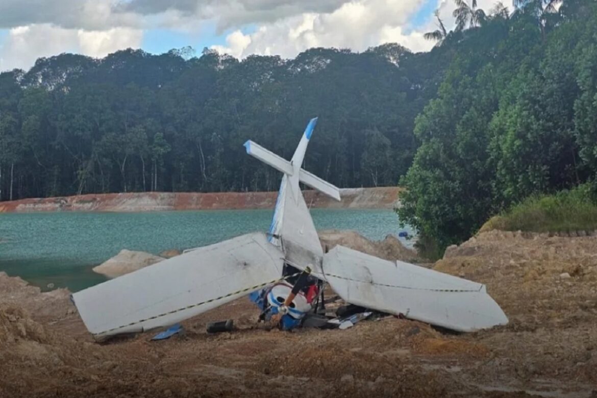 Destroços de monomotor branco caído às margens de lago esverdeado após urubu atingir hélice em área rural de mineradora