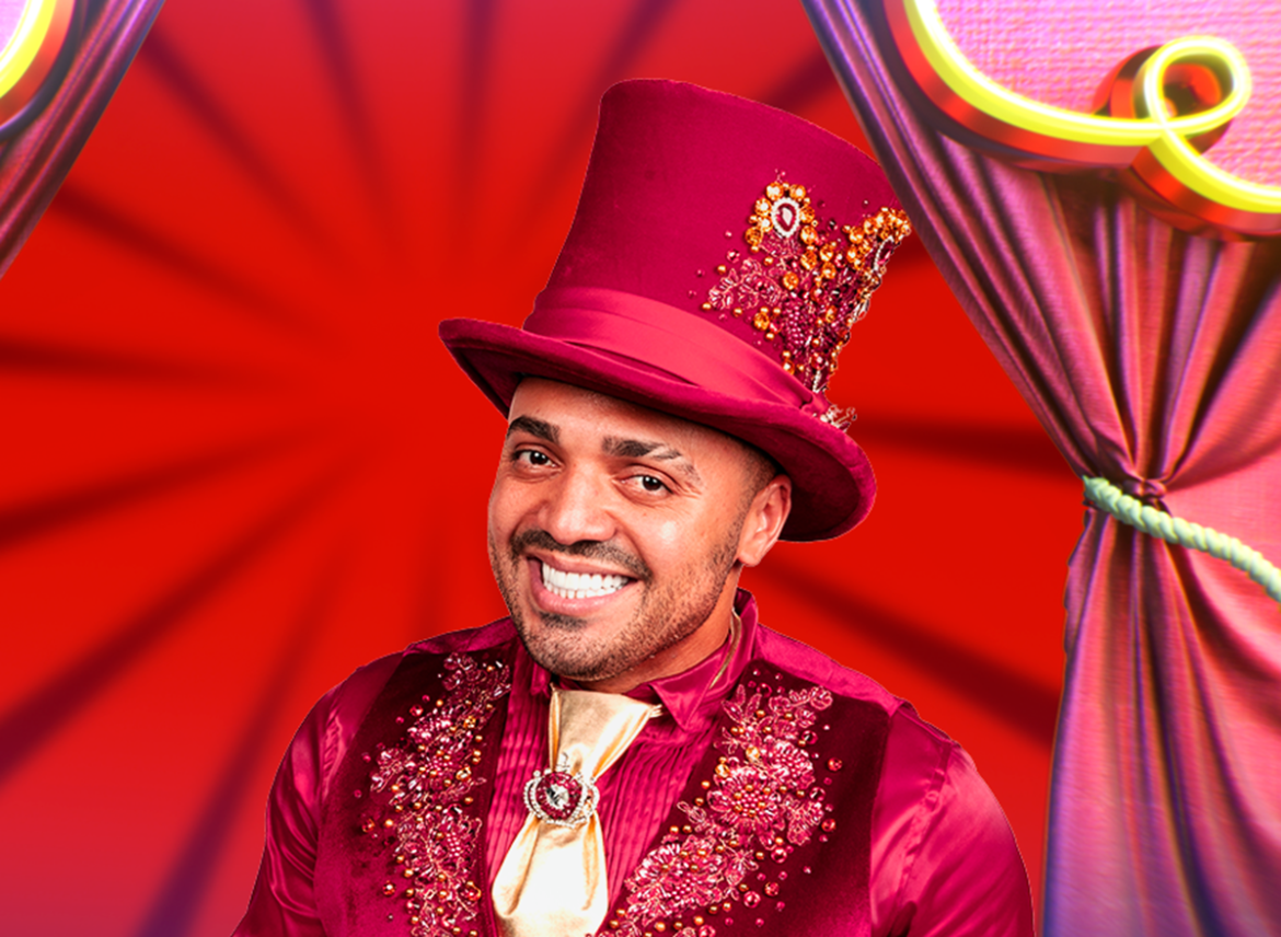 Tirullipa sorrindo com cartola magenta bordada e camisa de seda com aplicações douradas em cenário circense vermelho
