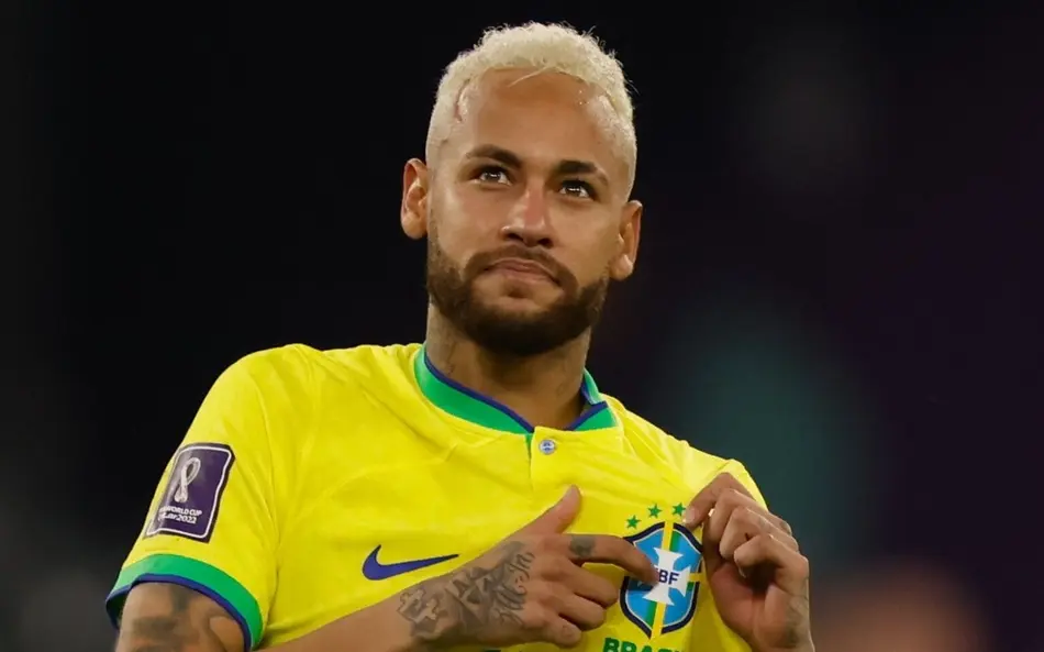 Dado impressionante de Neymar revela disparidade na Seleção: camisa 10 tem mais gols do que todos os outros 25 convocados juntos 6 Neymar com cabelo platinado usando a camisa amarela da Seleção Brasileira, apontando para o escudo da CBF