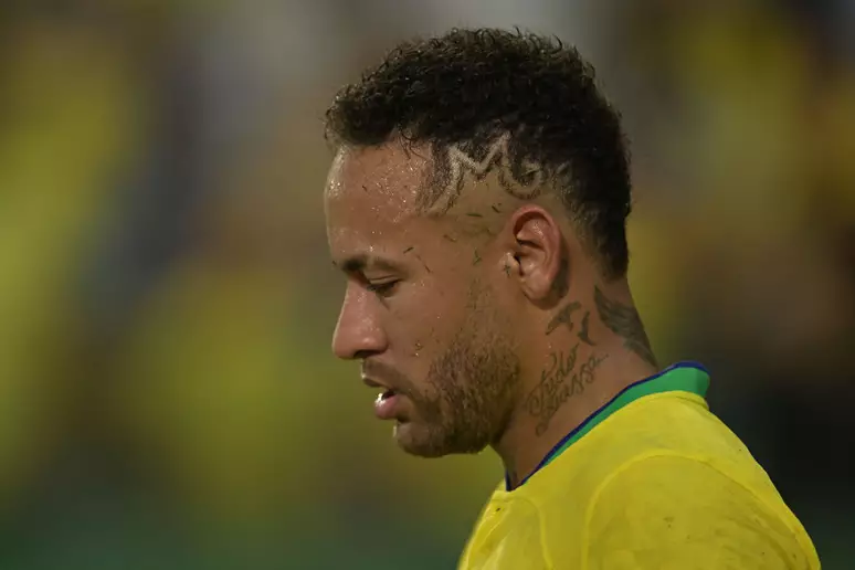 Adeus à estreia do hexa? Lesão de Neymar é grau 2 na panturrilha direita e CBF monitora corte até véspera de 13/06 6 Neymar de perfil, cabelo crespo curto com desenho, tatuagem no pescoço, vestindo camisa amarela da Seleção